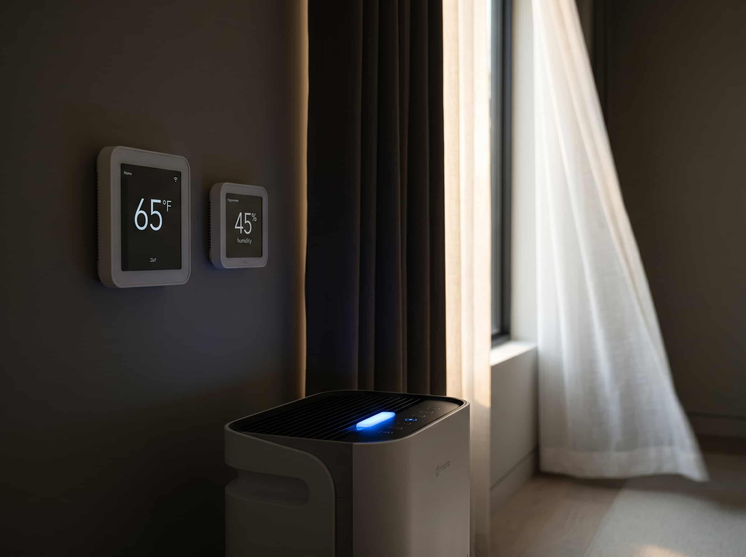 HEPA air purifier and digital thermostat in a minimalist bedroom, representing the air quality and temperature pillars of sleep sanctuary design
